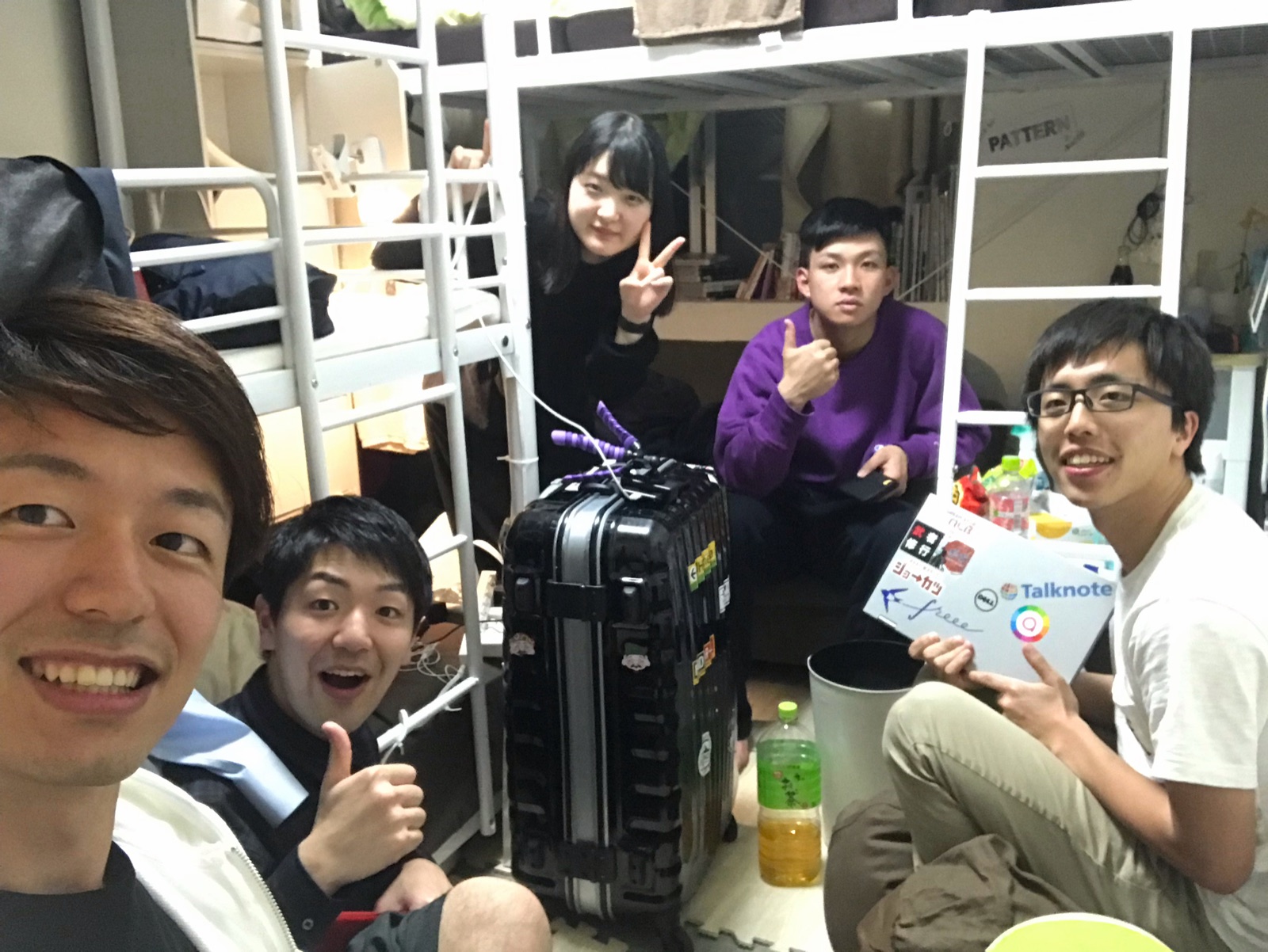 スーツケースを囲んで座る4人。到着したばかり